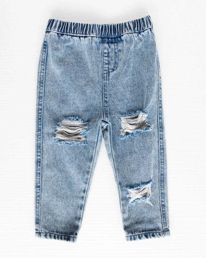 Distressed Denim Slim Leg Jeans. These trendy yet classic denim jeans are the answer to your outfit prayers! Pair with any top to bring your mini's style to the next level. Elastic waistband for easy pull-on wear. Dye-lots may vary slightly in color due to distressing process. 75% Cotton, 25% Polyester. Hand wash. Women owned.