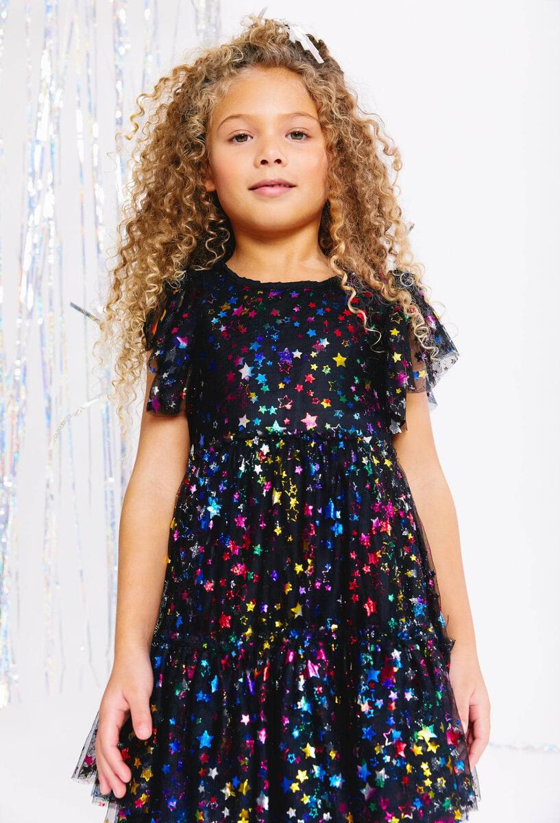 Make your little star shine at her next party in this Lola + The Boys Shining Rainbow Star Tulle Dress! Featuring a black tulle dress with a colorful shimmery star print, this is sure to be the perfect look for a special occasion! 