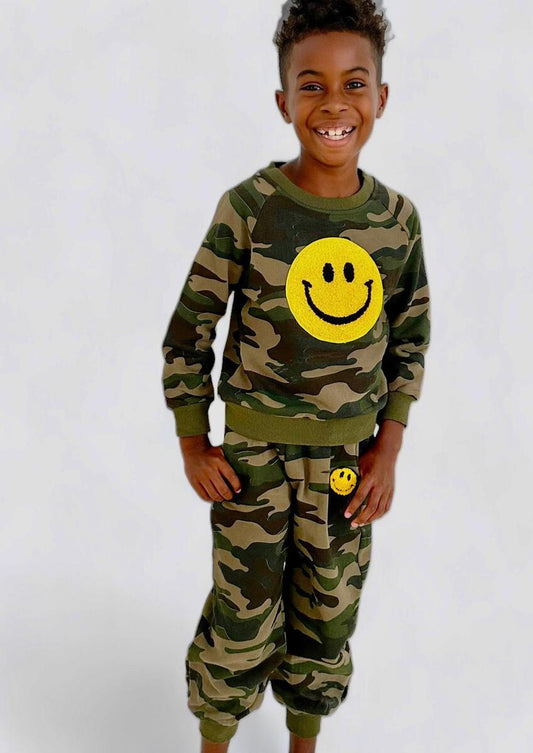 Stay comfy and keep it cute with this Lola + The Boys Camo Emoji Smiley Track Set! Features a pullover sweatshirt and matching jogger with fuzzy smiley decals, this soft fleece set is the easiest go-to outfit.   100% Cotton. Machine wash cold gentle. Hang or Tumble dry low (inside out). 