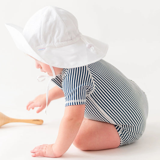 Keep your babe safe from the sun with this UPF 50+ protective one-piece swimsuit. This full coverage one piece suit makes trips to the pool, lake or beach so easy for little crawlers. Snaps at bottom make for easy changing.  58% Polyester, 34% Nylon, 8% Spandex. UPF 50+ sun protective fabric.