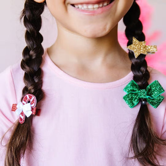 Sweet Wink Christmas Clip Set. Alligator clip style, ribbon-covered to grip the hair. Glitter accents are shed free. Set includes 1 candy cane hair clip, 1 green glitter bow hair clip, 1 gold glitter star hair clip.