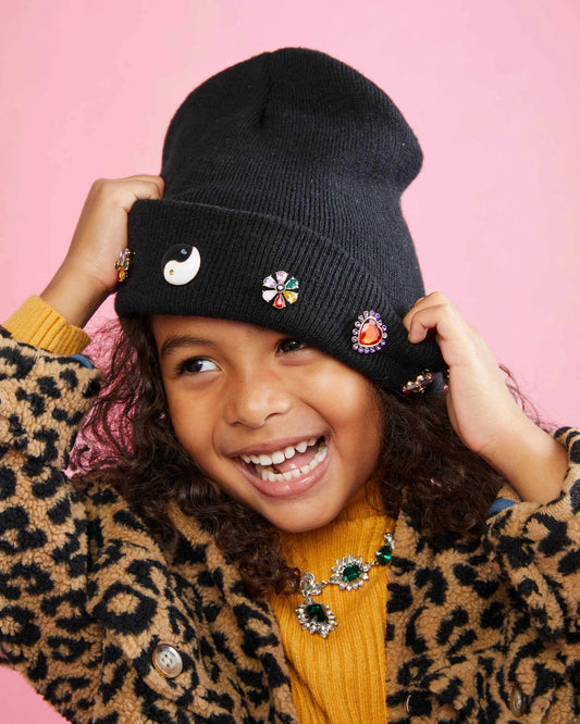 Don't let the cold keep you inside, it's time to seize the day. With the Carpe Diem Beanie, you can confidently head out into the cold for an afternoon of adventuring! Made from a super luxurious knit (our softest & warmest yet!) and covered in charms from every angle, this is a hit with little ones and tweens alike!  Small parts, not intended for children under 3 years.