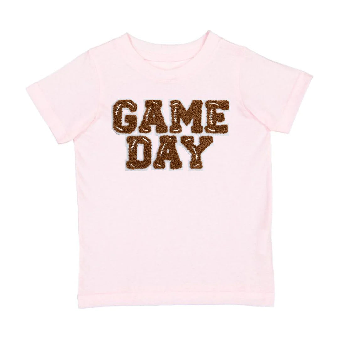 You'll score major points with the kiddos in our Pink Game Day Patch Tee! This super soft pink tee features a brown and white chenille patch with light grey outline, perfect for showing off their team spirit. It's tagless, topstitched ribbed collar and side seam construction make it comfy and durable to wear. Plus, each shirt is hand-pressed with child-safe inks for your peace of mind. Now, that's a winning combination!