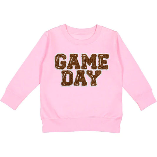You'll score major points with the kiddos in our Pink Game Day Patch Sweatshirt! This super soft pink pullover features a brown and white chenille patch with light grey outline, perfect for showing off their team spirit. It's tagless and fleece lined, making it comfy and durable to wear. Plus, each sweatshirt is hand-pressed with child-safe inks for your peace of mind. Now, that's a winning combination!  Women owned + designed by a Mother/Daughter duo in NYC.