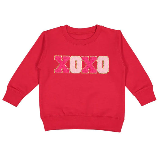 The Sweet Wink XOXO Patch Sweatshirt is a fun and festive sweatshirt for celebrating Valentine's Day! Features light and hot pink chenille with gold glitter outlined letters. Soft cotton for comfort. Tagless inside neck label for total comfort and itch-free wear; cozy fleece lining.  60% Cotton, 40% Polyester Fleece.  Machine washable, wash inside out, lay flat to dry.